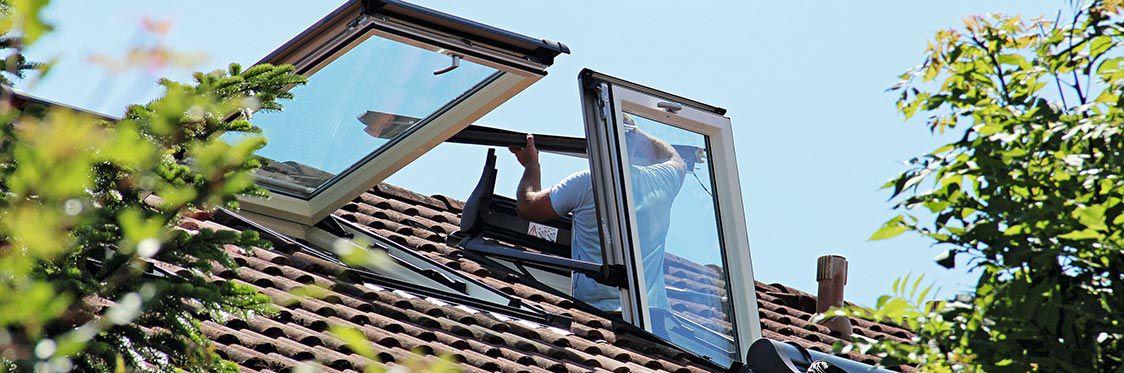 Ein Handwerker bei der Montage der Fenster auf dem Dach