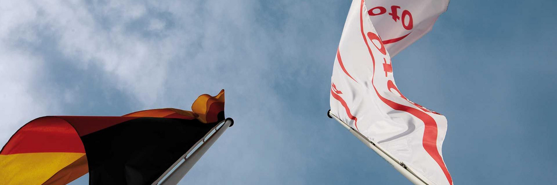 Die Roto Fahne sowie die Deutschlandflagge wehen im Wind