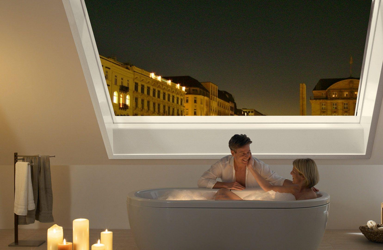 Una finestra panoramica per tetti Azuro aperta sul cielo notturno crea un’atmosfera romantica nel bagno