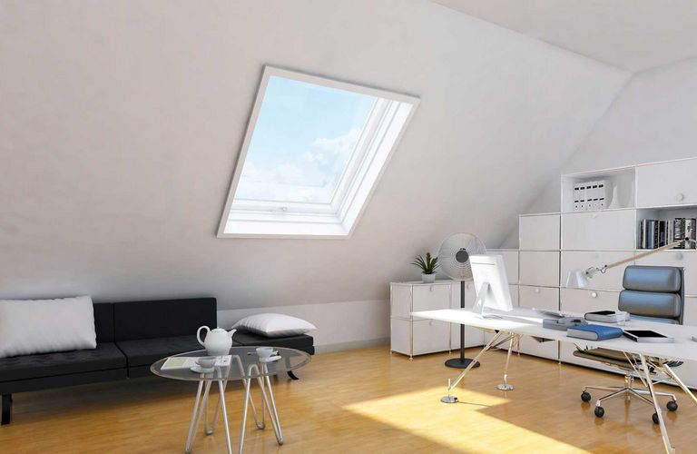 Studio minimal nel sottotetto con grandi finestre che fanno molta luce