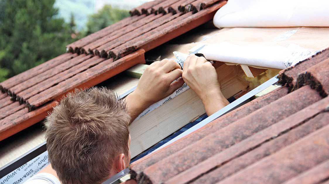 Ein Handwerker beim Anbringen von Fensterdämmung