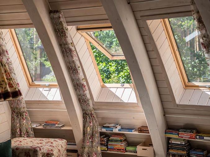 Gemütliche Leseecke in einem Holzhaus mit Dachfenstern ebenfalls aus Holz