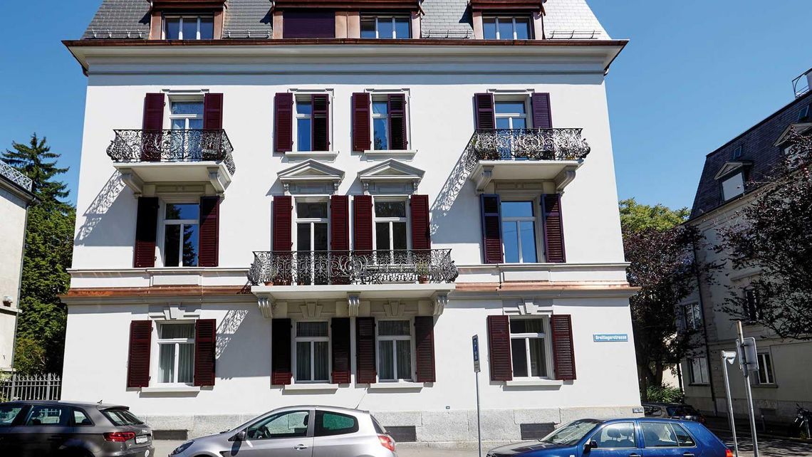 Renoviertes Haus mit parkenden Autos davor